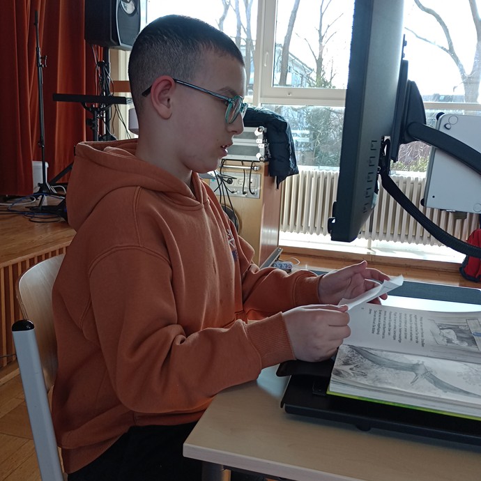 Schüler liest mithilfe eines Bildschirmlesegeräts (vergrößerte Bildansicht wird geöffnet)