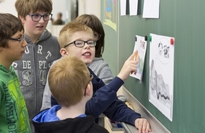 Schüler erklärt seinen Mitschülern etwas an der Tafel